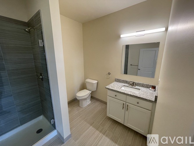 A bathroom with a toilet, sink, and shower.