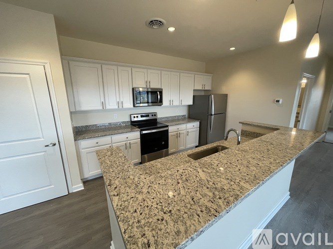 A kitchen with granite countertops and white cabinets.