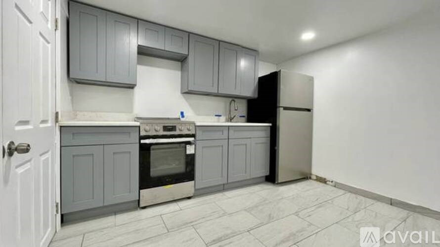 A kitchen with grey cabinets and a white door.