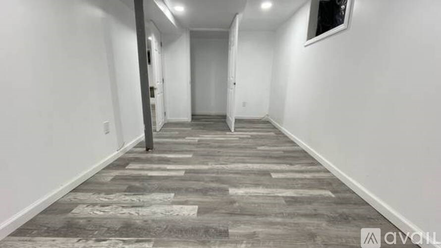 A long hallway with a carpeted floor and white walls.