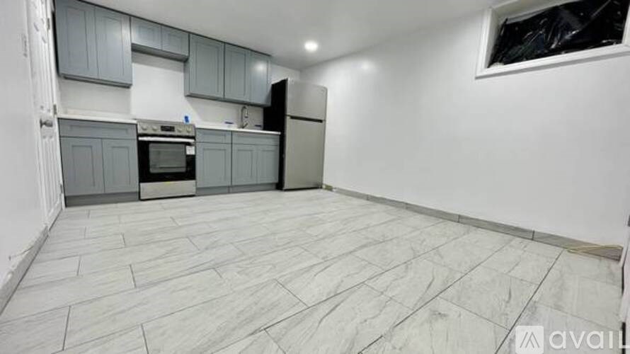 A kitchen with grey cabinets and a tiled floor.