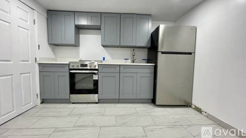 A kitchen with a stove top oven and a refrigerator.
