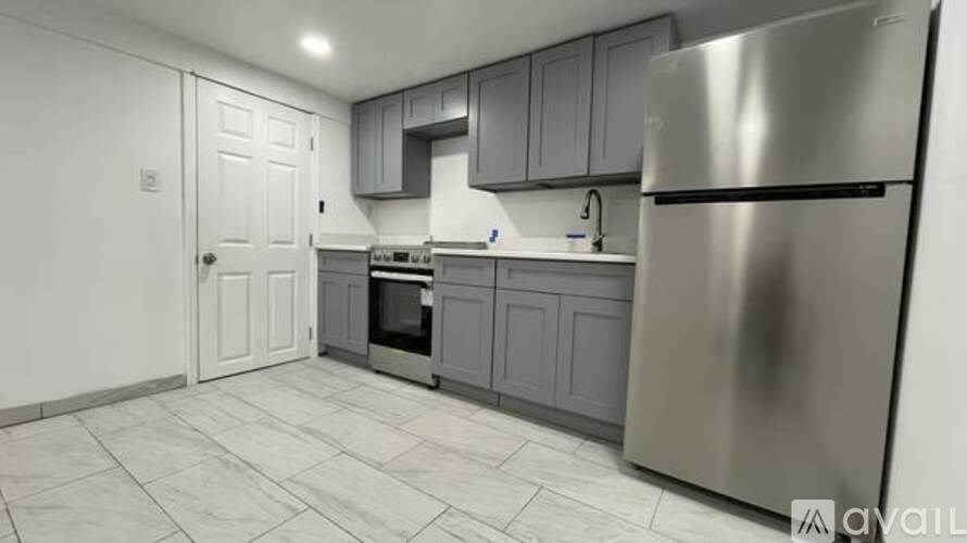 A kitchen with a stainless steel refrigerator and a white door.