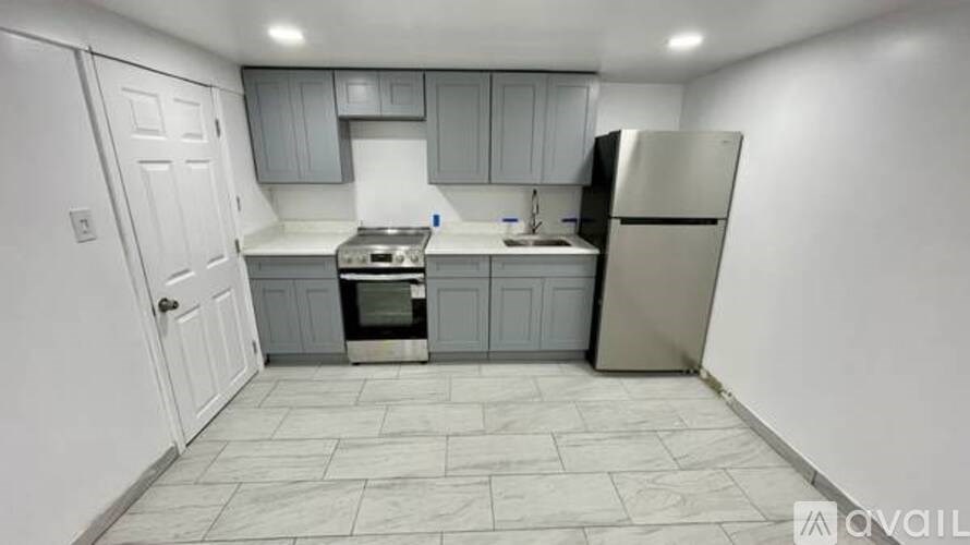A kitchen with a stove, sink, and refrigerator.