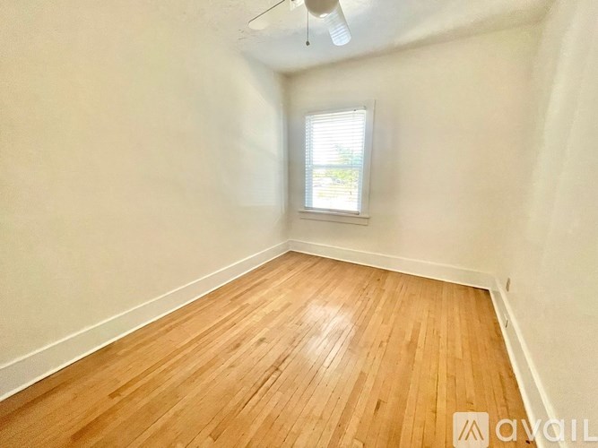 A room with wooden flooring and a window.