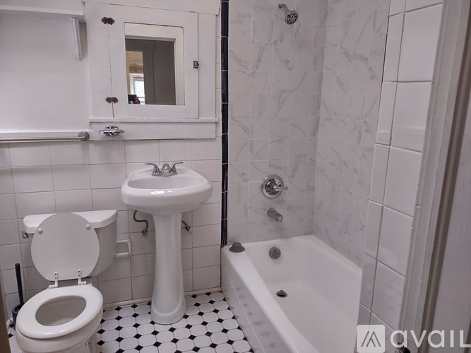 A white sink and toilet in a bathroom with a black and white checkered floor.