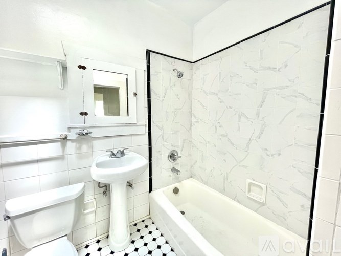 A white bathroom with a black and white checkered floor.