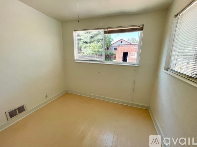 A room with a window and a view of a building outside.
