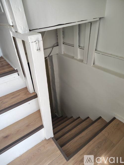 A set of stairs with a white wall on the side.