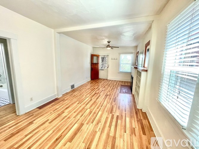 A room with wooden flooring and a ceiling fan.