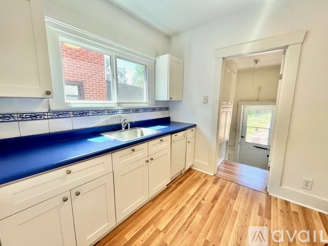 A kitchen with white cabinets and a blue countertop.