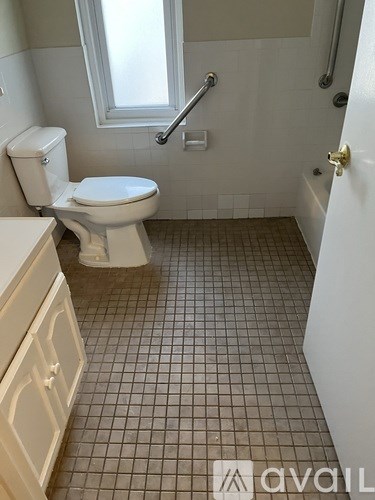 A white toilet in a bathroom with tiled floors and walls.
