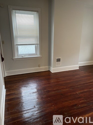 A room with a window and wooden floors.