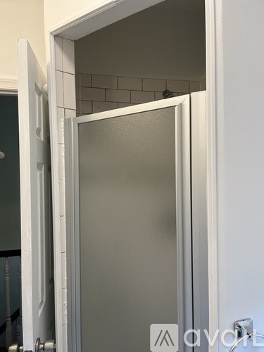 A white door is open to a bathroom.