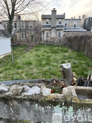 A backyard with a wall and a tree.