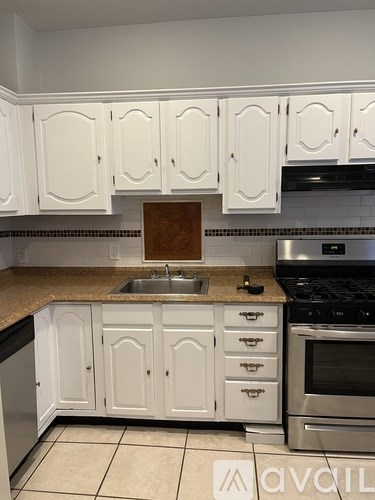 A kitchen with white cabinets and a granite countertop.