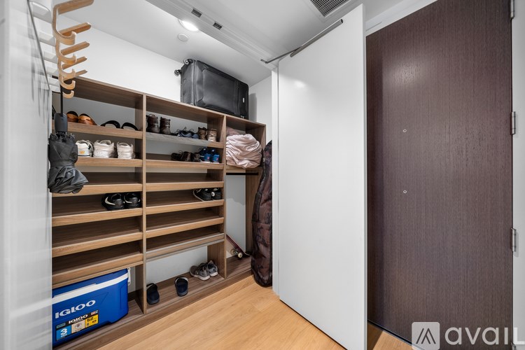 A room with a shoe rack and a box labeled "Iacon" on the floor.