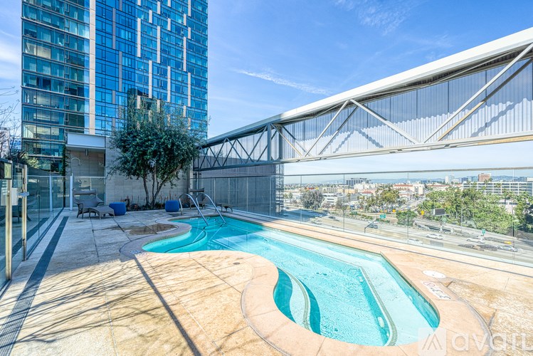 A swimming pool on a rooftop with a glass building in the background.