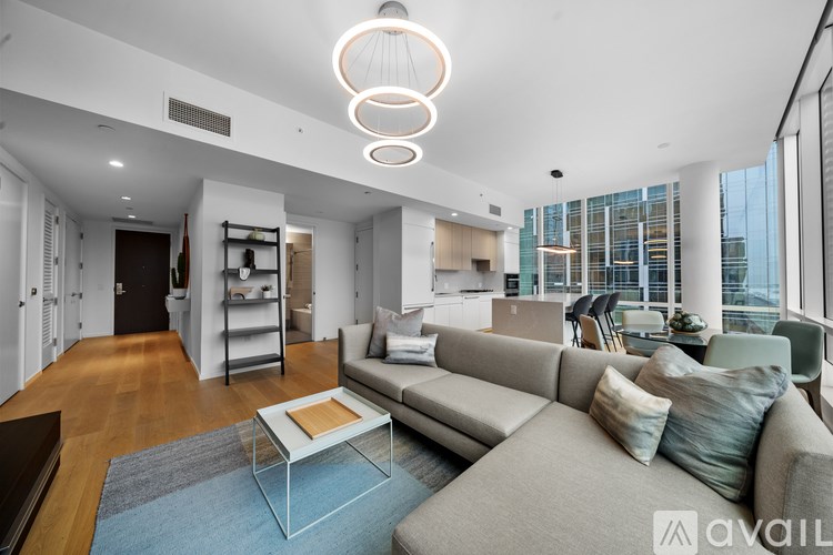 A modern living room with a grey sofa and a glass coffee table.