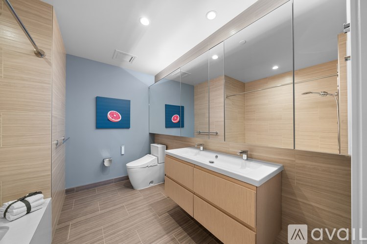 A modern bathroom with a wooden vanity and a white toilet.