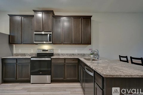 A kitchen with brown cabinets and a granite countertop.