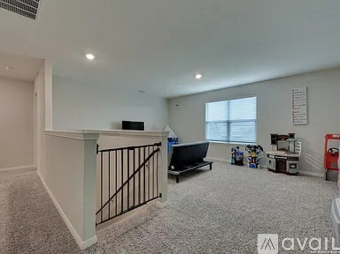 A room with a black sofa and a white wall with a window.