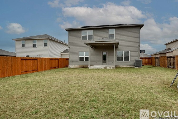 A two-story house with a grey exterior and a large front yard.