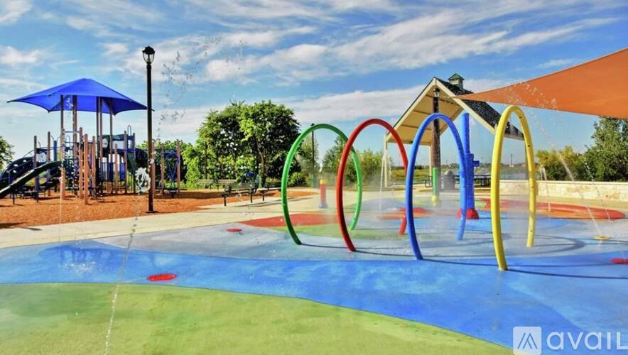 A playground with a blue umbrella and a slide.