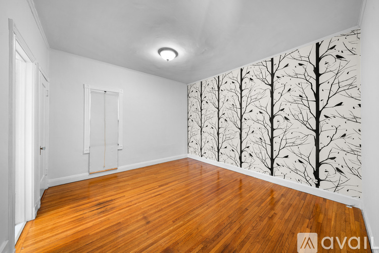 A room with wooden floors and a wallpaper of trees.