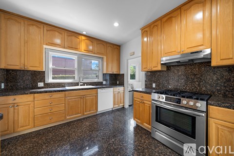 A kitchen with wooden cabinets and granite countertops.