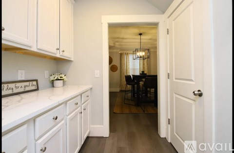 A kitchen with white cabinets and a sign that says "I lay for a good boy".