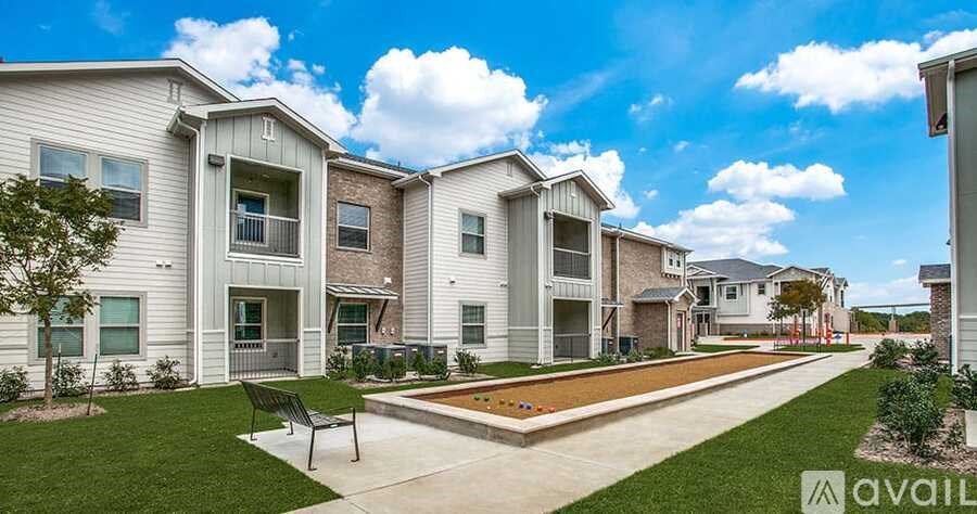 A row of modern houses with a grassy front yard and a bench.