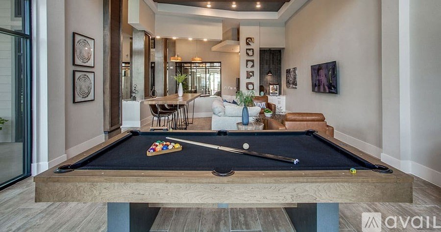 A pool table is in the middle of a room with a couch and a dining table.