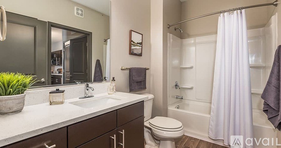 A bathroom with a white sink, toilet, and bathtub.
