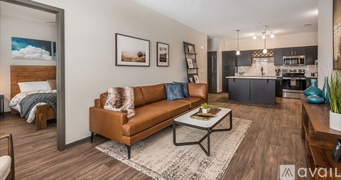 A living room with a brown couch and a coffee table in the center.