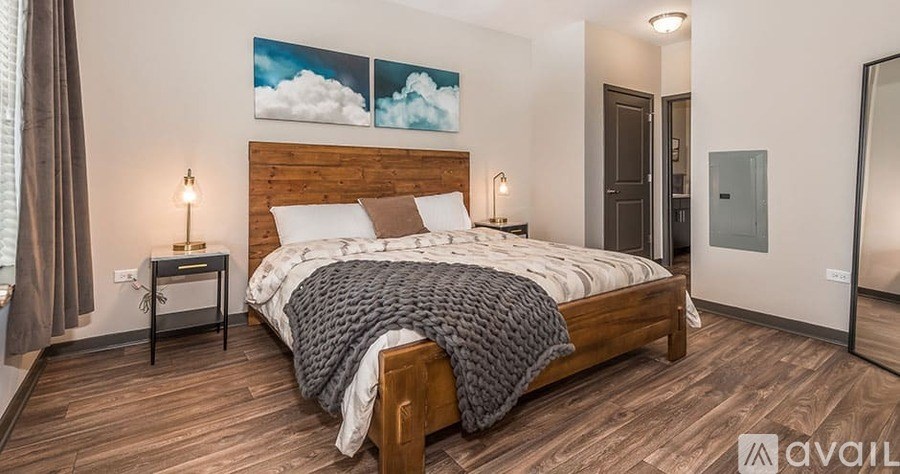 A bedroom with a large bed and a wooden headboard.