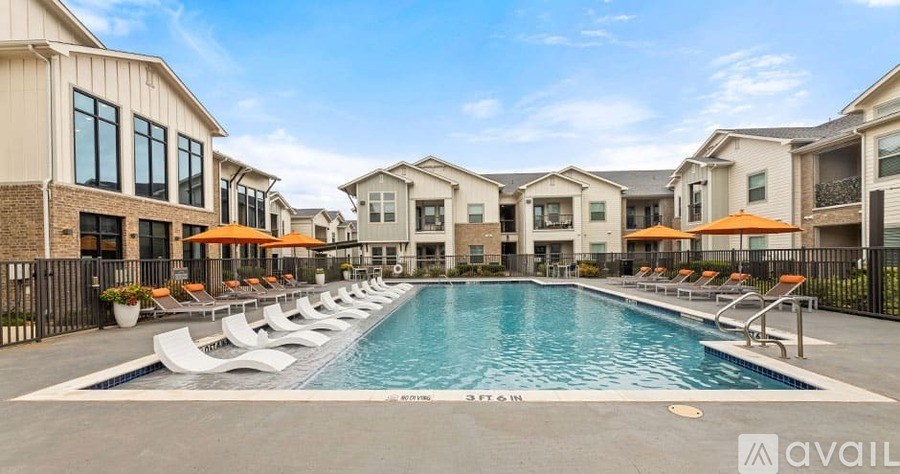 A swimming pool surrounded by lounge chairs and buildings.