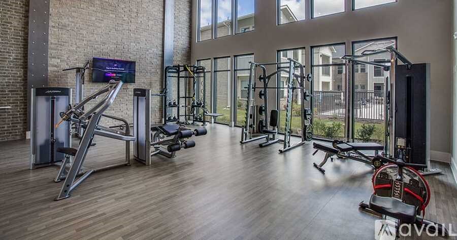 A gym with a variety of equipment including a treadmill, weights, and a television.