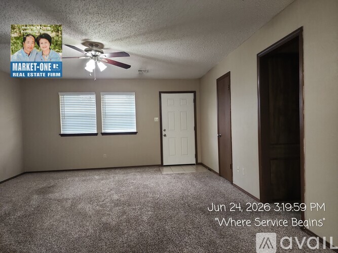 A room with a ceiling fan and carpeted floor.