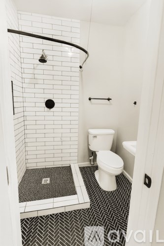 A white toilet in a bathroom with a black and white tiled floor.