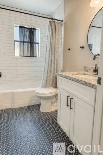 A bathroom with a white toilet and a patterned floor.