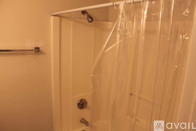 A shower with a glass door and a white door with a handle.