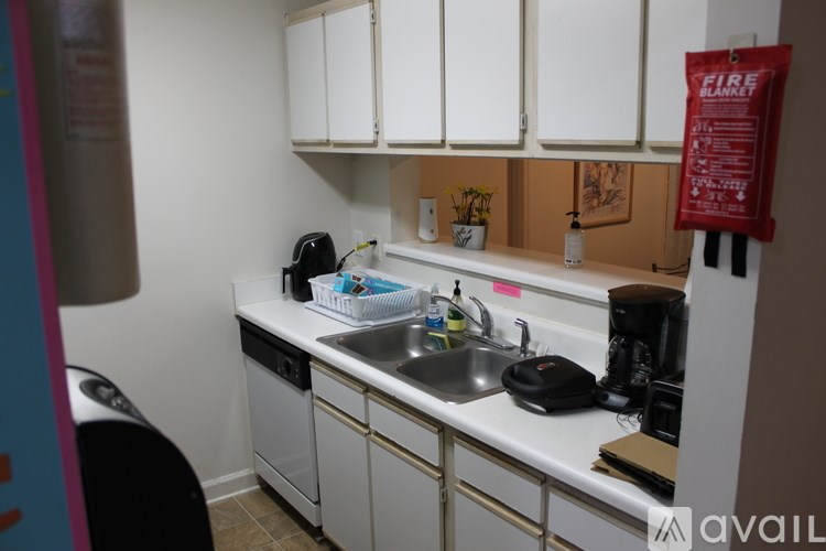 A kitchen with white cabinets and a black toaster on the counter.