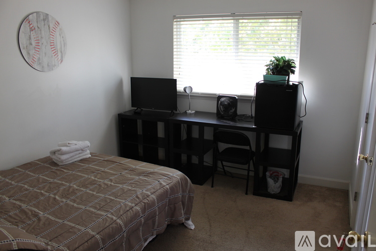 A bedroom with a bed, desk, and chair.