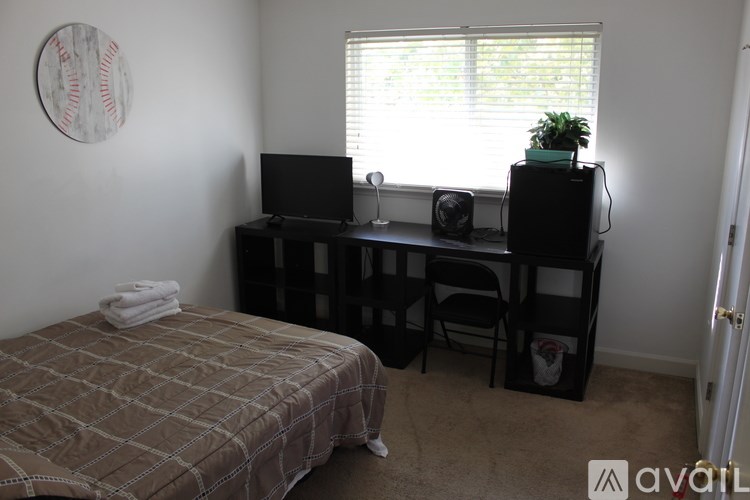 A bedroom with a bed, desk, and chair.