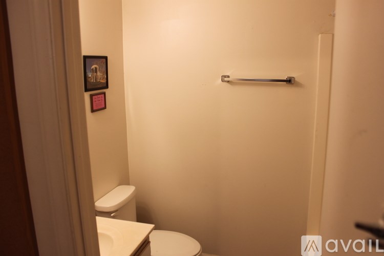 A small bathroom with a toilet and a towel bar.