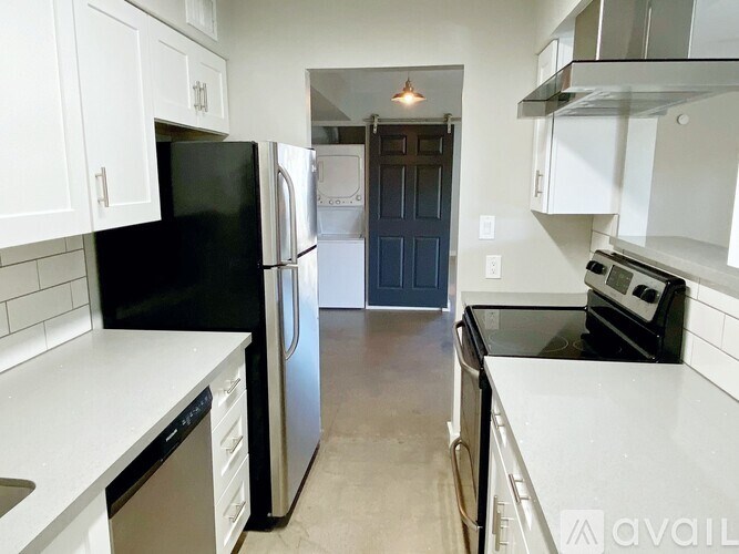A kitchen with black and white appliances and cabinets.