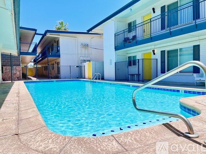 A swimming pool in front of a building with a metal railing.