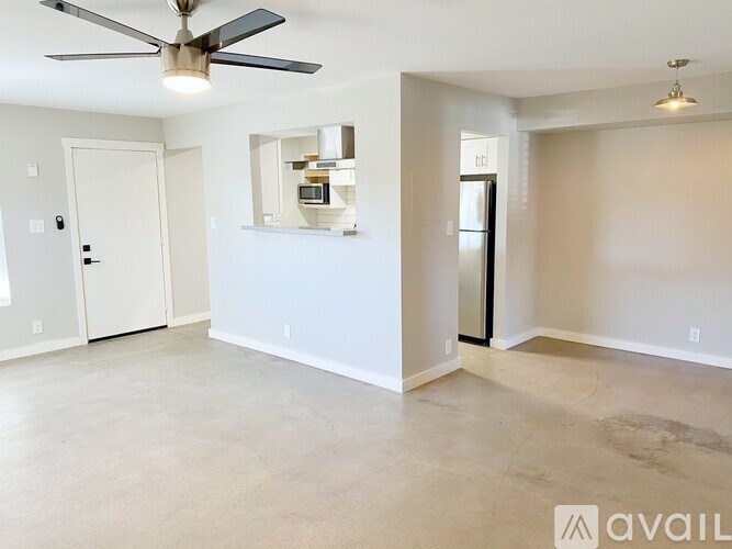 A spacious room with a ceiling fan and a mirror on the wall.