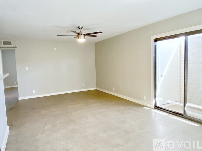 A spacious room with a ceiling fan and sliding glass doors.